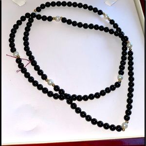 Onyx and pearl strand necklace with 14K gold accents. 28”